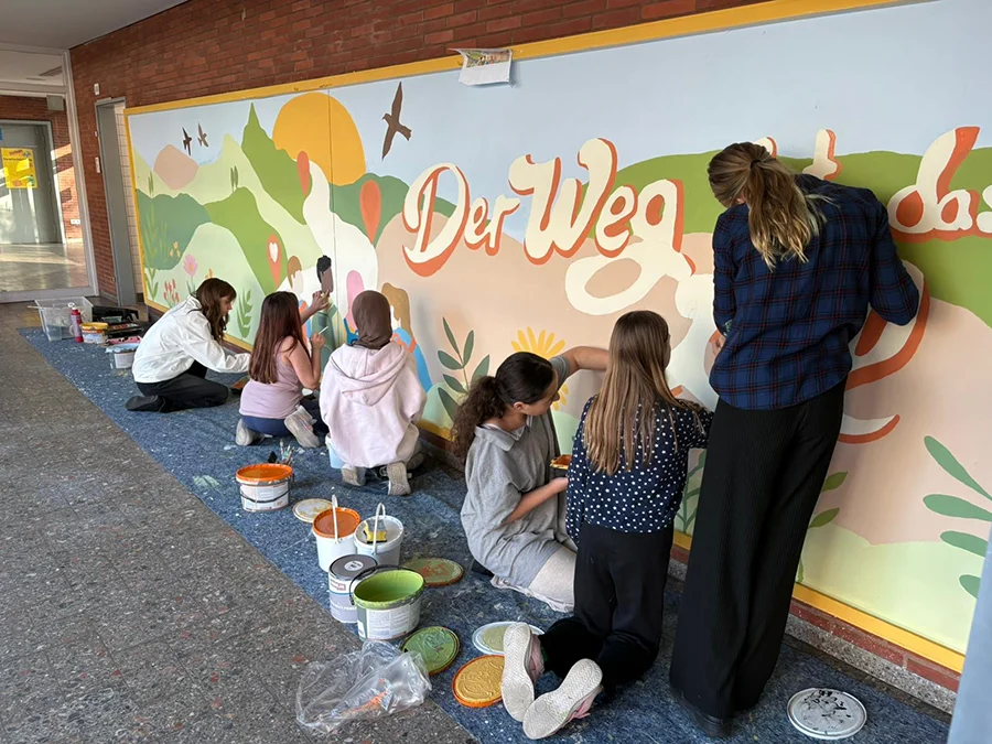 Schülerinnen und Schüler malen ein Wandbild