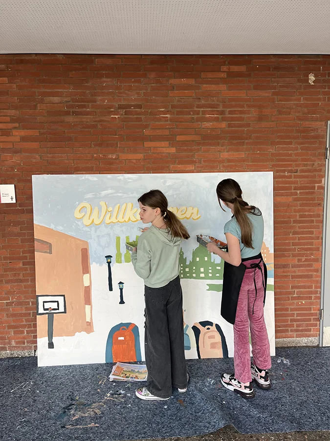 Schülerinnen bemalen kleines Bild